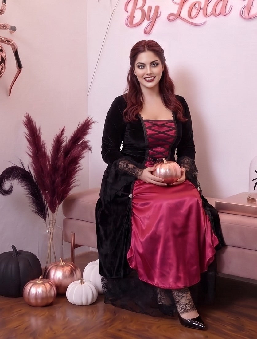 disfraz de vampiresa gótica compuesto por un vestido de terciopelo negro y satén rojo. El vestido presenta un corpiño con cordones frontales en el escote, mangas de encaje negro acampanadas y una falda larga de encaje con vuelo.