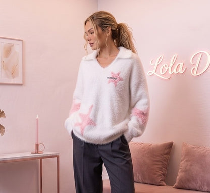 Jersey oversize de mujer en punto peluche suave con escote en pico y solapas, estampado de estrellas a contraste y detalle bordado en el pecho, disponible en blanco con estrellas rosa y granate con estrellas azul turquesa