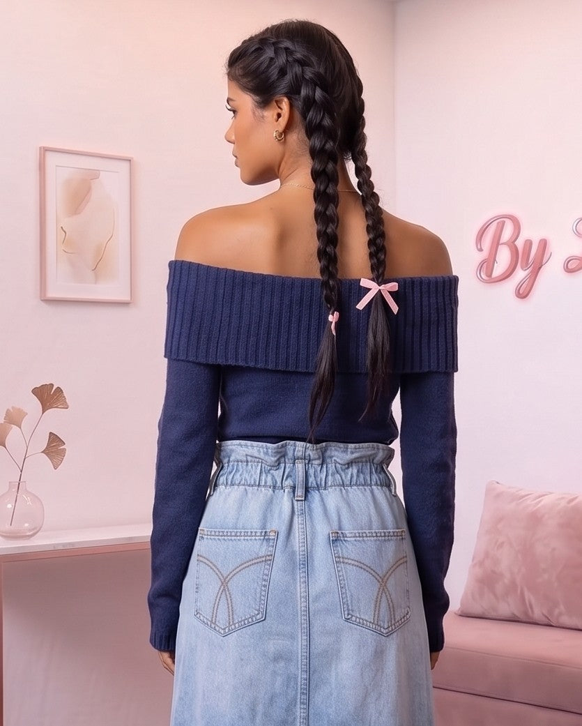 Jersey corto de punto fino acanalado para mujer con escote barco de hombros caídos y manga larga, disponible en azul marino, blanco roto y negro clásico sobre fondo de boutique.