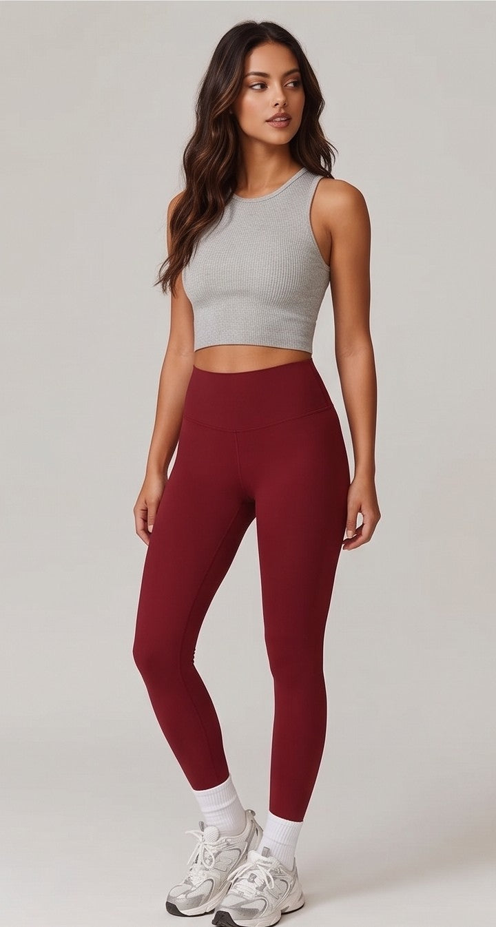 Leggins deportivos lisos de tiro alto y cintura ancha moldeadora para mujer, confeccionados en tejido elástico transpirable sin costuras frontales, corte tobillero y costura trasera anatómica con efecto realce, disponibles en color burdeos, rosa pastel, verde salvia, verde oliva, beige claro, gris perla, gris grafito, azul cielo, verde lima y negro.