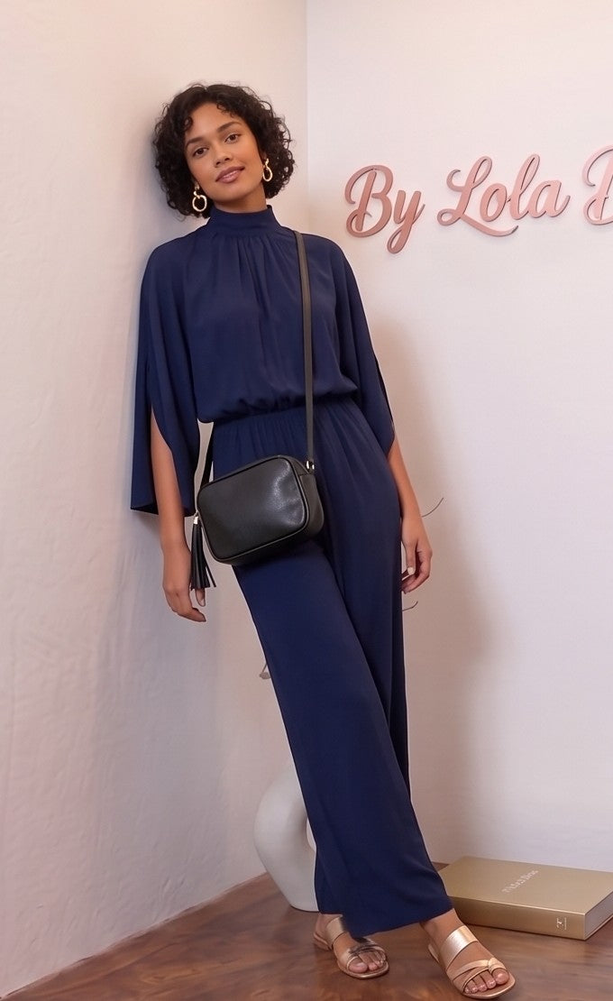 Mono largo de fiesta para mujer disponible en 5 colores (verde esmeralda, azul marino, negro, burdeos y champán dorado), con elegante cuello perkins fruncido, mangas estilo capa con abertura lateral, cintura elástica entallada y pernera ancha y fluida tipo palazzo, ideal para look de invitada de boda y eventos de gala