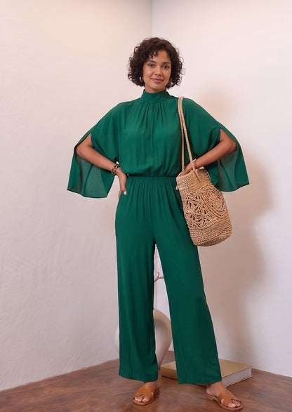 Mono largo de fiesta para mujer disponible en 5 colores (verde esmeralda, azul marino, negro, burdeos y champán dorado), con elegante cuello perkins fruncido, mangas estilo capa con abertura lateral, cintura elástica entallada y pernera ancha y fluida tipo palazzo, ideal para look de invitada de boda y eventos de gala