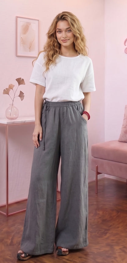 Pantalón ancho para mujer en mezcla de algodón y lino, diseño recto y fluido de tiro alto con cintura elástica fruncida, bolsillos funcionales y detalle de cordón ajustable anudado en el lateral de la cintura, disponible en una variedad de colores lisos.