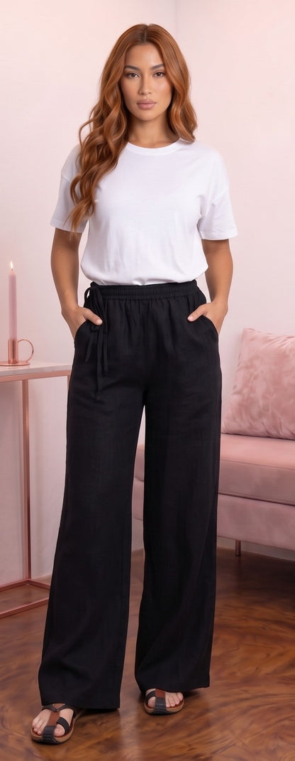 Pantalón ancho para mujer en mezcla de algodón y lino, diseño recto y fluido de tiro alto con cintura elástica fruncida, bolsillos funcionales y detalle de cordón ajustable anudado en el lateral de la cintura, disponible en una variedad de colores lisos.