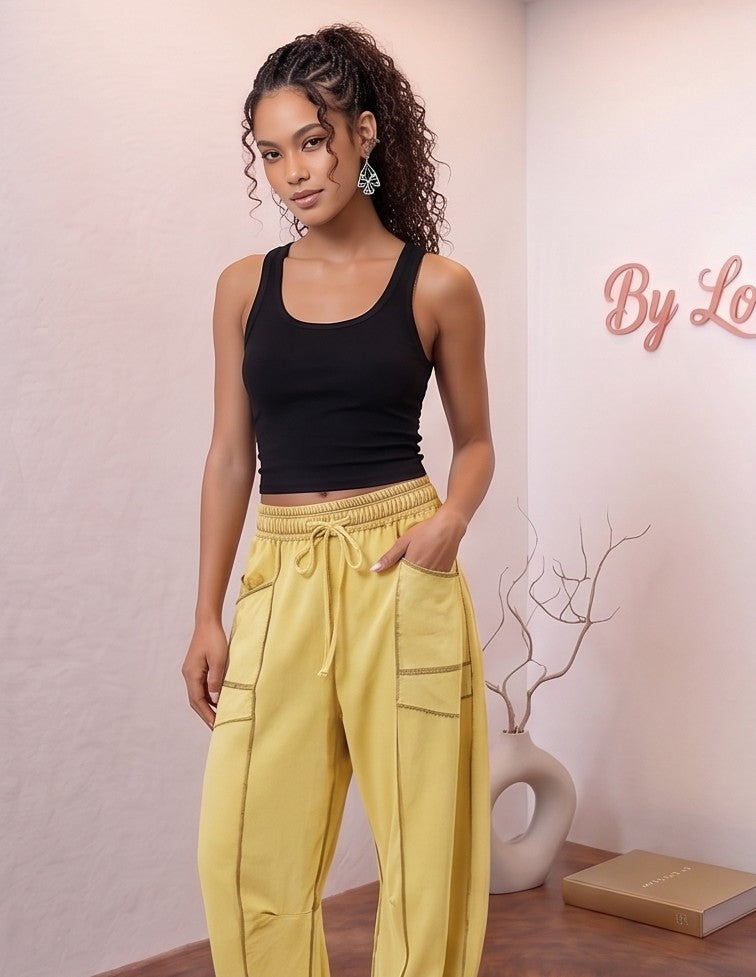Pantalón fluido estilo bombacho wide leg para mujer con cintura elástica de cordón ajustable, costuras vistas en contraste y bolsillos cargo laterales geométricos, disponible en 8 colores: amarillo pastel, azul celeste, verde esmeralda, blanco tiza, beige arena, marrón chocolate, azul marino y negro con pespuntes dorados