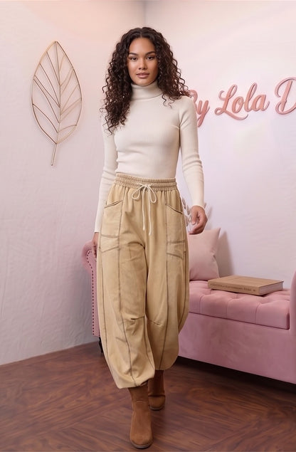 Pantalón fluido estilo bombacho wide leg para mujer con cintura elástica de cordón ajustable, costuras vistas en contraste y bolsillos cargo laterales geométricos, disponible en 8 colores: amarillo pastel, azul celeste, verde esmeralda, blanco tiza, beige arena, marrón chocolate, azul marino y negro con pespuntes dorados