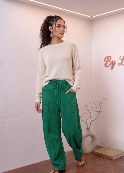 Pantalón fluido estilo bombacho wide leg para mujer con cintura elástica de cordón ajustable, costuras vistas en contraste y bolsillos cargo laterales geométricos, disponible en 8 colores: amarillo pastel, azul celeste, verde esmeralda, blanco tiza, beige arena, marrón chocolate, azul marino y negro con pespuntes dorados