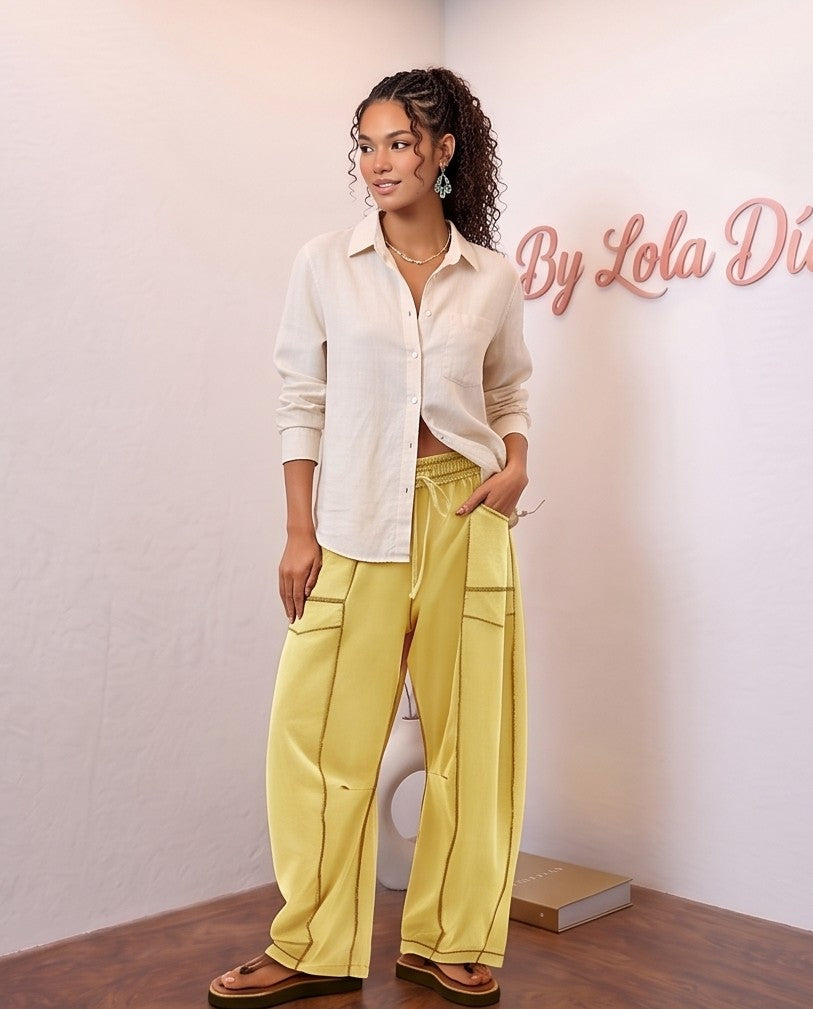 Pantalón fluido estilo bombacho wide leg para mujer con cintura elástica de cordón ajustable, costuras vistas en contraste y bolsillos cargo laterales geométricos, disponible en 8 colores: amarillo pastel, azul celeste, verde esmeralda, blanco tiza, beige arena, marrón chocolate, azul marino y negro con pespuntes dorados