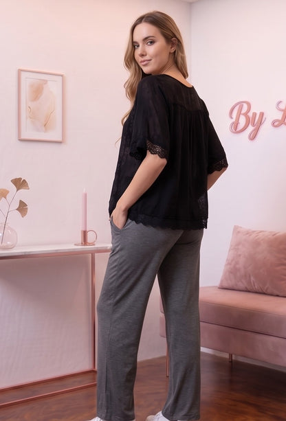 Detalle del dobladillo, costuras y acabado de Pantalón premamá de corte recto y pierna ancha para embarazo y posparto, disponible en color negro, gris claro vigoré y gris marengo oscuro. Confeccionado en tejido elástico extrasuave efecto seda, con banda sobre la barriga con elástico y botón regulable interior, bolsillos laterales y caída holgada.