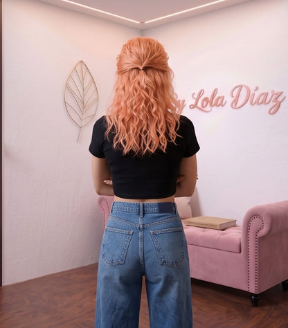Pantalón vaquero azul para mujer de estilo urbano y casual. Diseño de pierna ancha y tiro alto, largo tobillero 9/10, con distintivos bolsillos delanteros cuadrados tipo parche y cierre clásico de botón. Tejido denim liso.