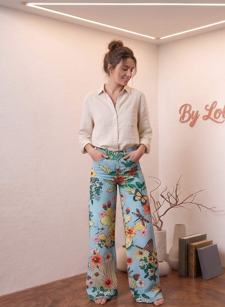 Pantalón vaquero palazzo de tiro alto para mujer con pernera ancha, confeccionado en tejido denim fluido y disponible en una colección de 8 colores y acabados: estampados psicodélicos retro, margaritas sobre fondo gris, motivos botánicos con cactus, hojas tropicales, animal print de leopardo combinado con flores y grecas vintage en azul y rosa.