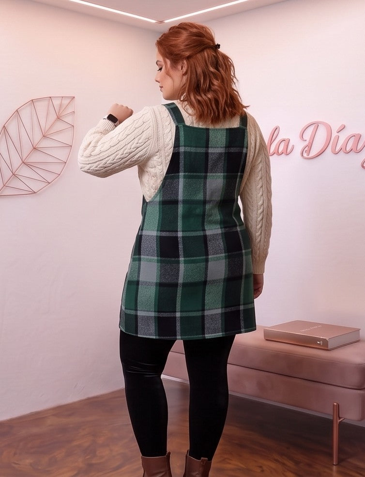 Peto vestido pichi corto para mujer curvy en estampado clásico de cuadros escoceses con corte línea A, tirantes anchos con botones y bolsillo frontal plastrón, confeccionado en mezcla de poliéster cálido, disponible en tonos verde botella, marrón camel y gris con negro sobre jersey de punto.