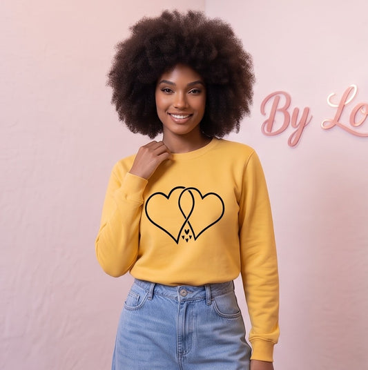 Sudadera de algodón para mujer con corte holgado y cuello redondo, manga larga con puños elásticos y estampado gráfico de dos corazones entrelazados en el pecho, disponible en siete colores: blanco, negro, gris, rosa, amarillo, verde y vino tinto