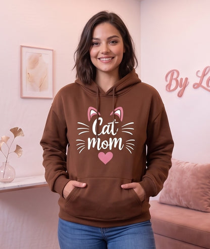 Sudadera hoodie con capucha de mujer corte holgado con estampado Cat Mom, orejitas de gato y corazón central. Diseño casual con bolsillo canguro delantero y mangas largas abullonadas, disponible en 8 colores: rosa, blanco, negro, gris jaspeado, marrón café, verde oscuro, albaricoque y morado