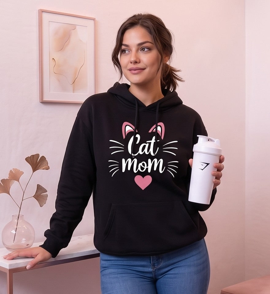 Sudadera hoodie con capucha de mujer corte holgado con estampado Cat Mom, orejitas de gato y corazón central. Diseño casual con bolsillo canguro delantero y mangas largas abullonadas, disponible en 8 colores: rosa, blanco, negro, gris jaspeado, marrón café, verde oscuro, albaricoque y morado