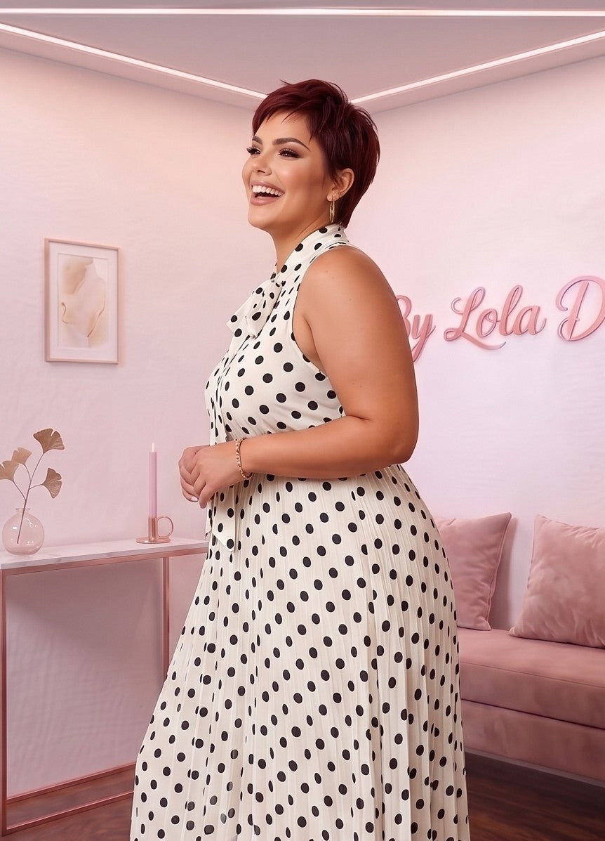 Vestido largo plisado de lunares con silueta evasé en corte A, diseño sin mangas con cuello alto anudado con lazo al frente y cinturón de lazo en la espalda. Disponible en tallas plus size (0XL a 4XL) y en cinco tonos: blanco, negro, café, rojo burdeos y azul marino
