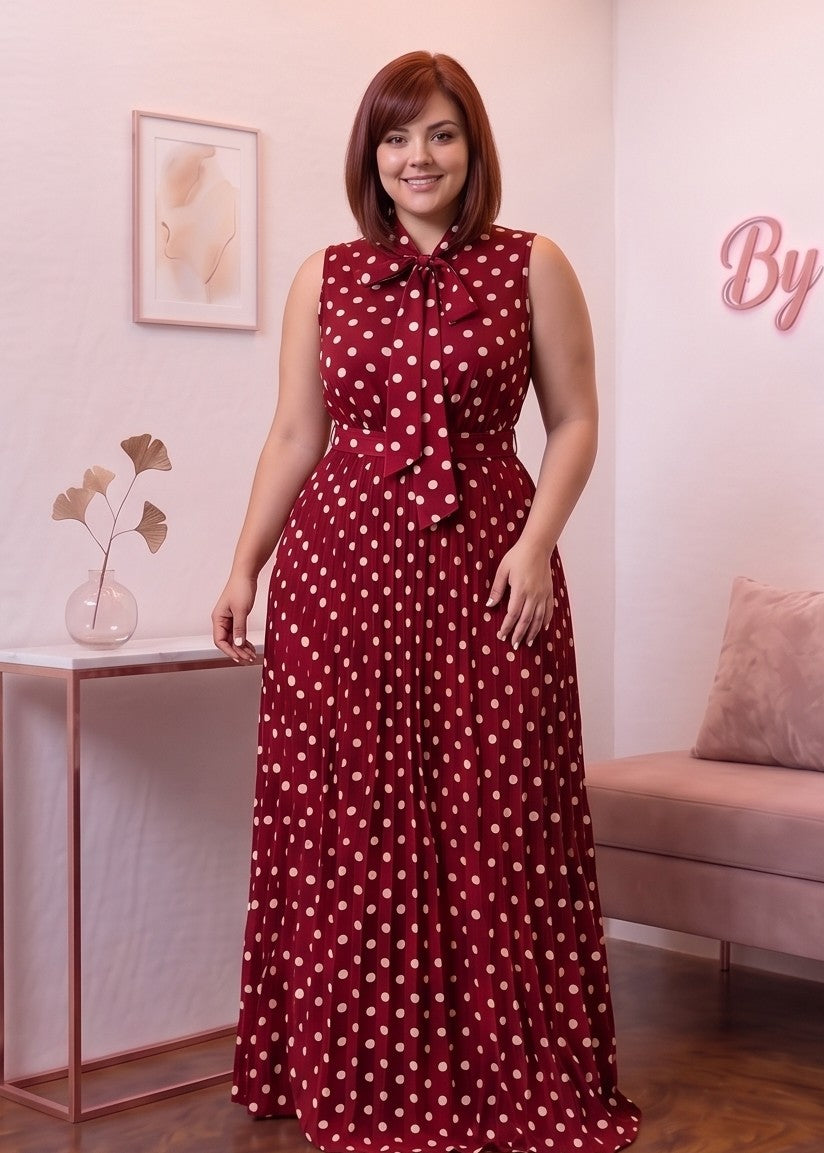 Vestido largo plisado de lunares con silueta evasé en corte A, diseño sin mangas con cuello alto anudado con lazo al frente y cinturón de lazo en la espalda. Disponible en tallas plus size (0XL a 4XL) y en cinco tonos: blanco, negro, café, rojo burdeos y azul marino