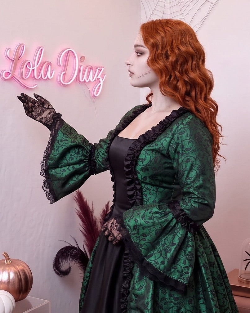 Vestido de época victoriana y corte medieval para mujer en tejido de damasco satinado con estampado floral barroco y panel frontal liso en contraste; presenta escote cuadrado ribeteado con encaje fruncido, mangas largas acampanadas estilo campana, corpiño ajustable tipo corsé en la espalda con lazada y gargantilla a juego. Disponible en cinco variantes de color combinadas con negro: verde esmeralda, morado berenjena, rojo granate, azul petróleo y blanco plateado.