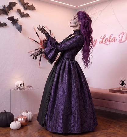 Vestido de época victoriana y corte medieval para mujer en tejido de damasco satinado con estampado floral barroco y panel frontal liso en contraste; presenta escote cuadrado ribeteado con encaje fruncido, mangas largas acampanadas estilo campana, corpiño ajustable tipo corsé en la espalda con lazada y gargantilla a juego. Disponible en cinco variantes de color combinadas con negro: verde esmeralda, morado berenjena, rojo granate, azul petróleo y blanco plateado.Vestido de época victoriana y corte medieval 