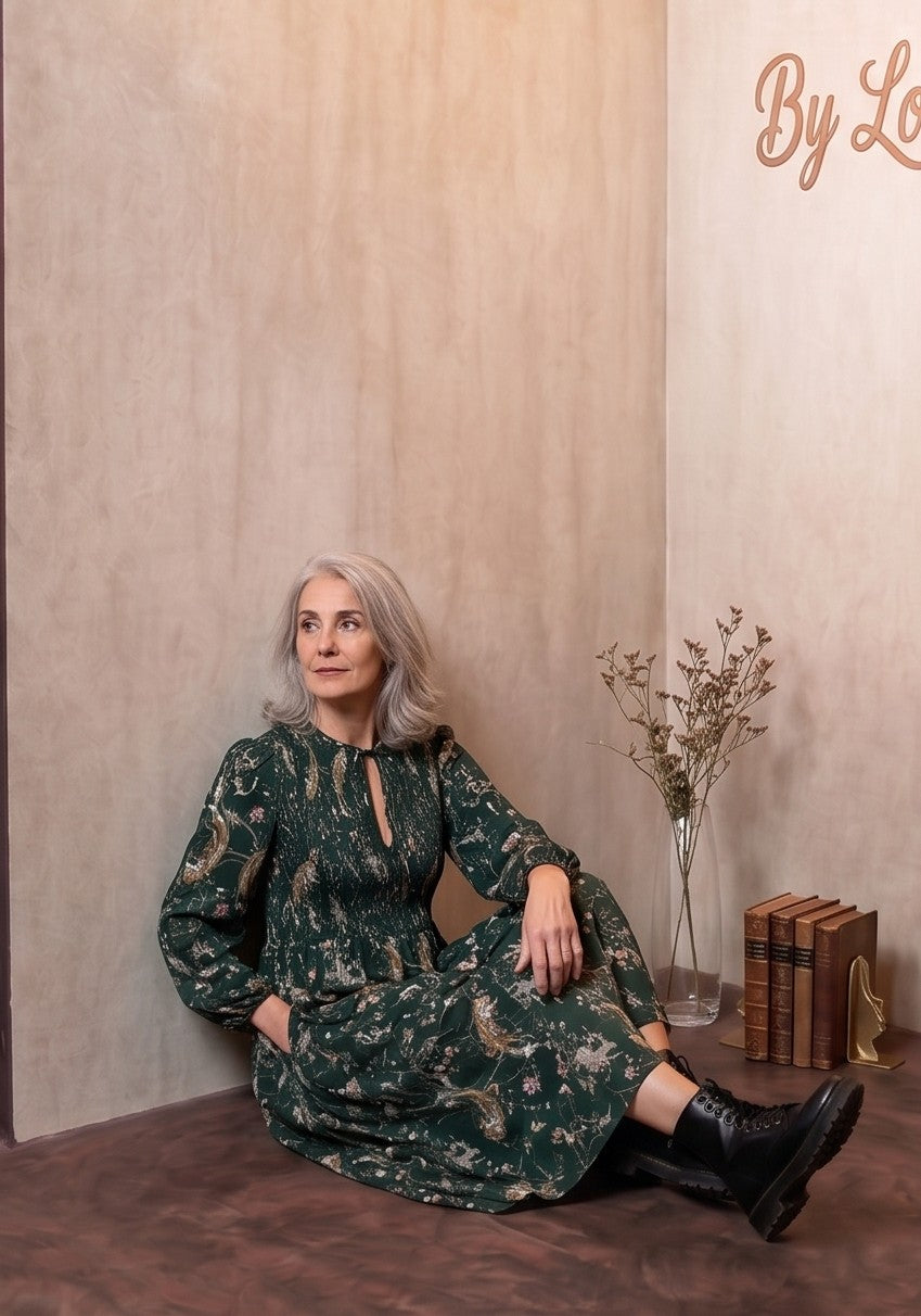vestido midi verde esmeralda, con un estampado flores de inspiración natural, tiene cuello con cordón y mangas largas abullonadas