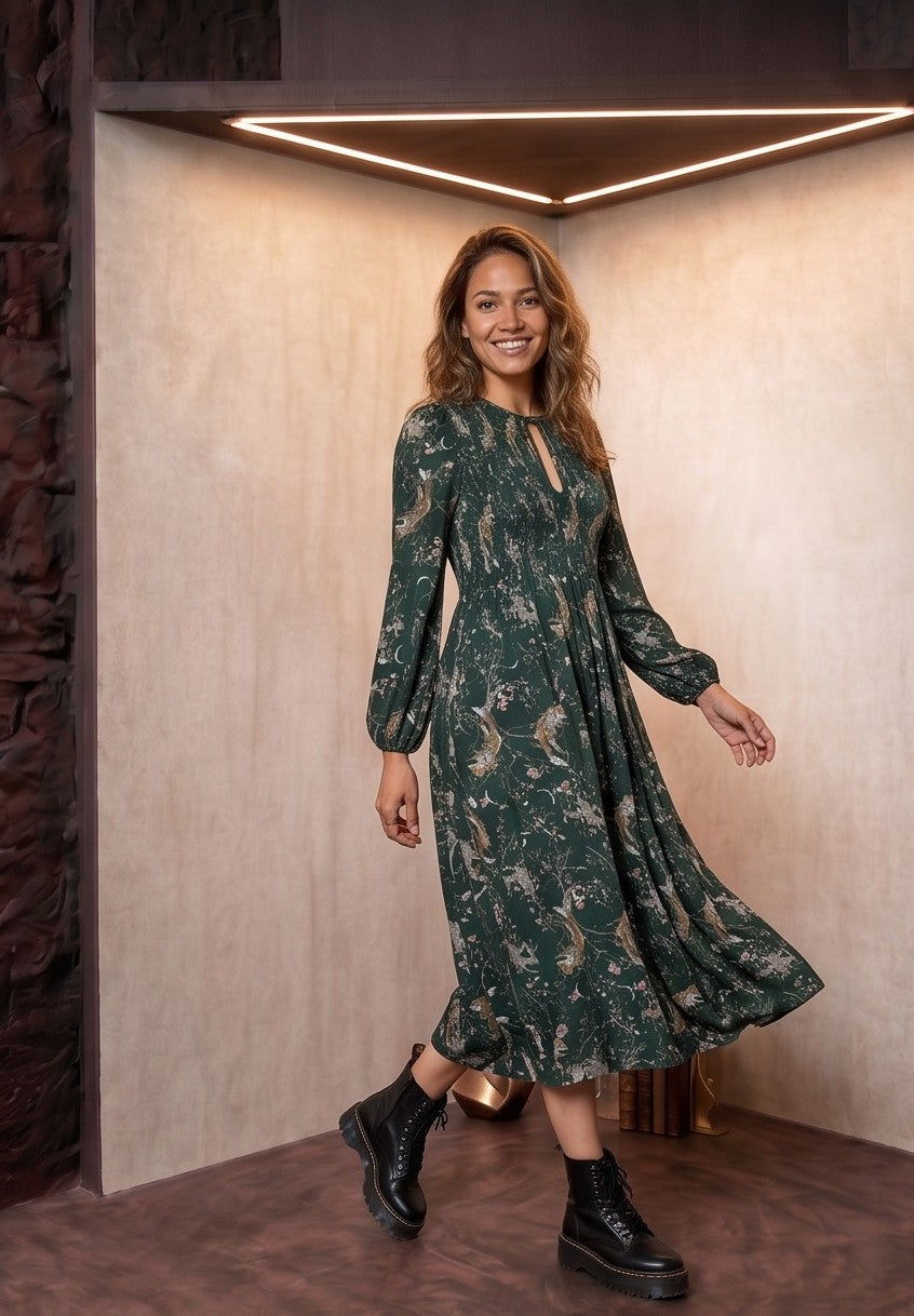 vestido midi verde esmeralda, con un estampado flores de inspiración natural, tiene cuello con cordón y mangas largas abullonadas